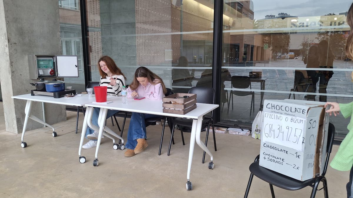 Yalila y Marta repartiendo chocolate y bollos